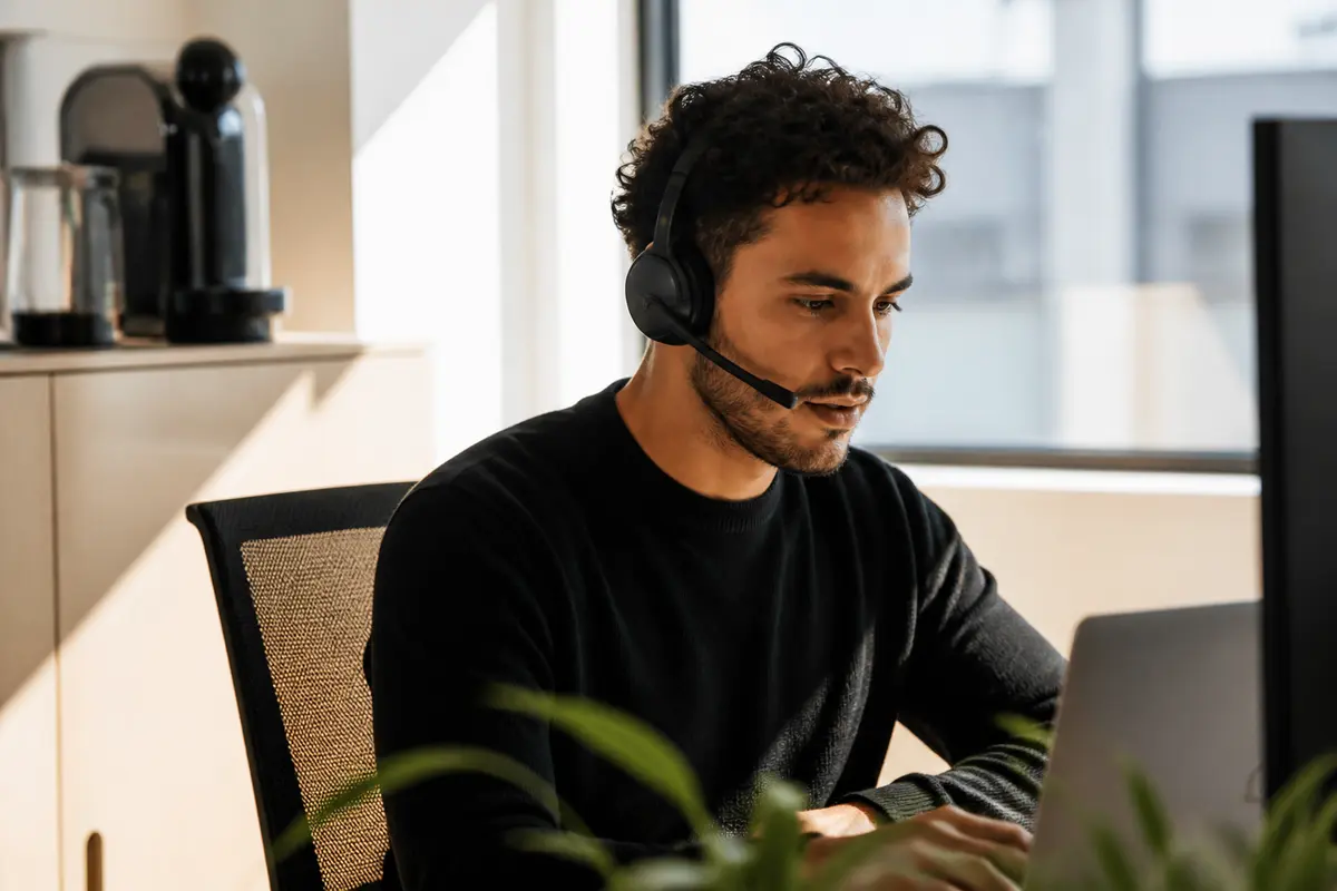 Homme avec casque travaillant sur ordinateur pour le service client de Nespresso